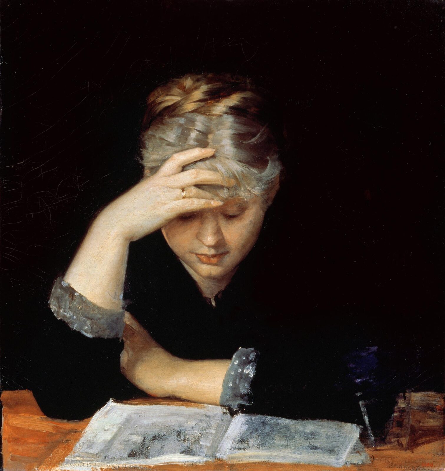 A fair-haired young woman in black, seen close up against a dark ground, leaning on a bare table with an open book before her, one hand pressed to her forehead and her eyes lowered to the page.